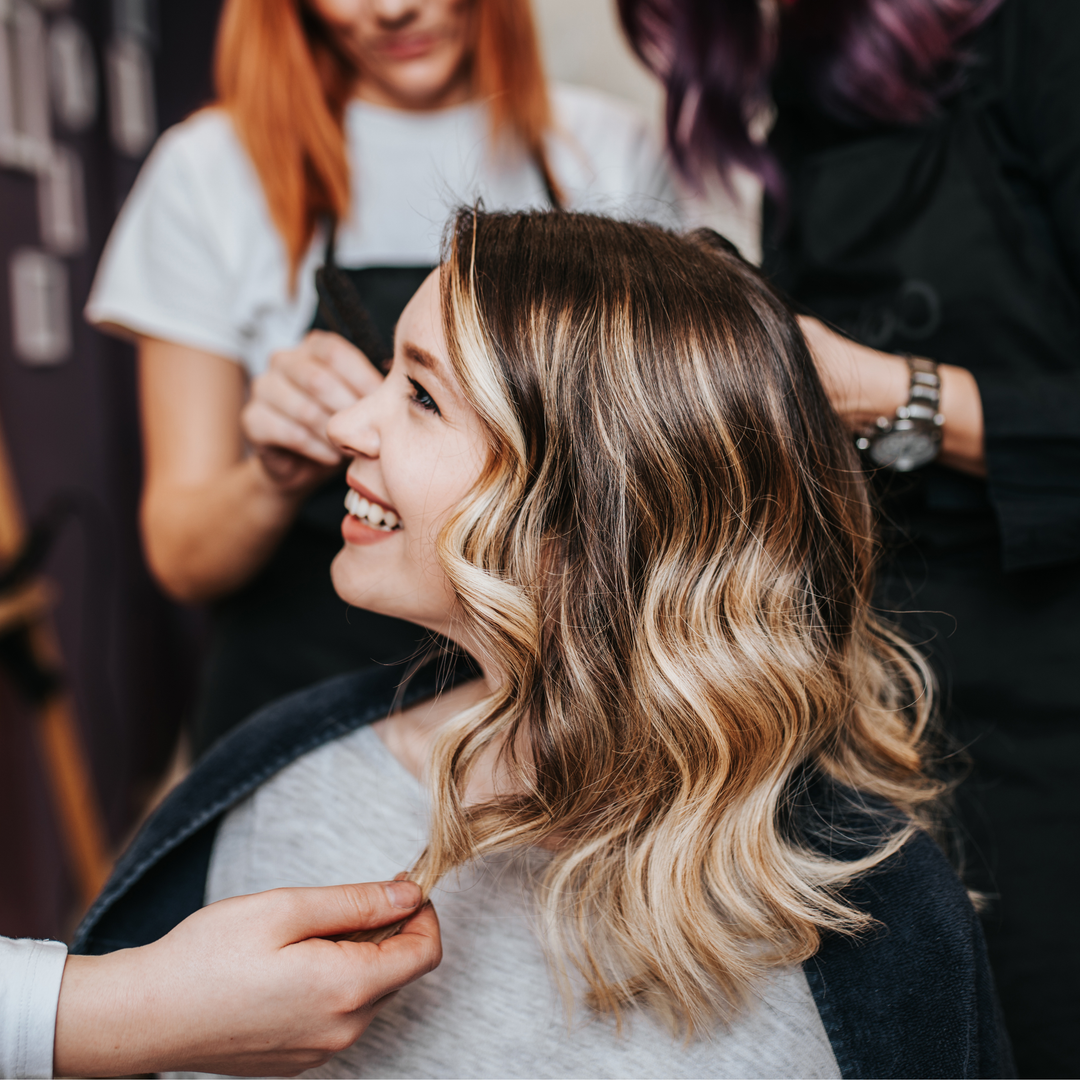 Mani che massaggiano delicatamente l'olio di ricino sul cuoio capelluto o sulle punte dei capelli.