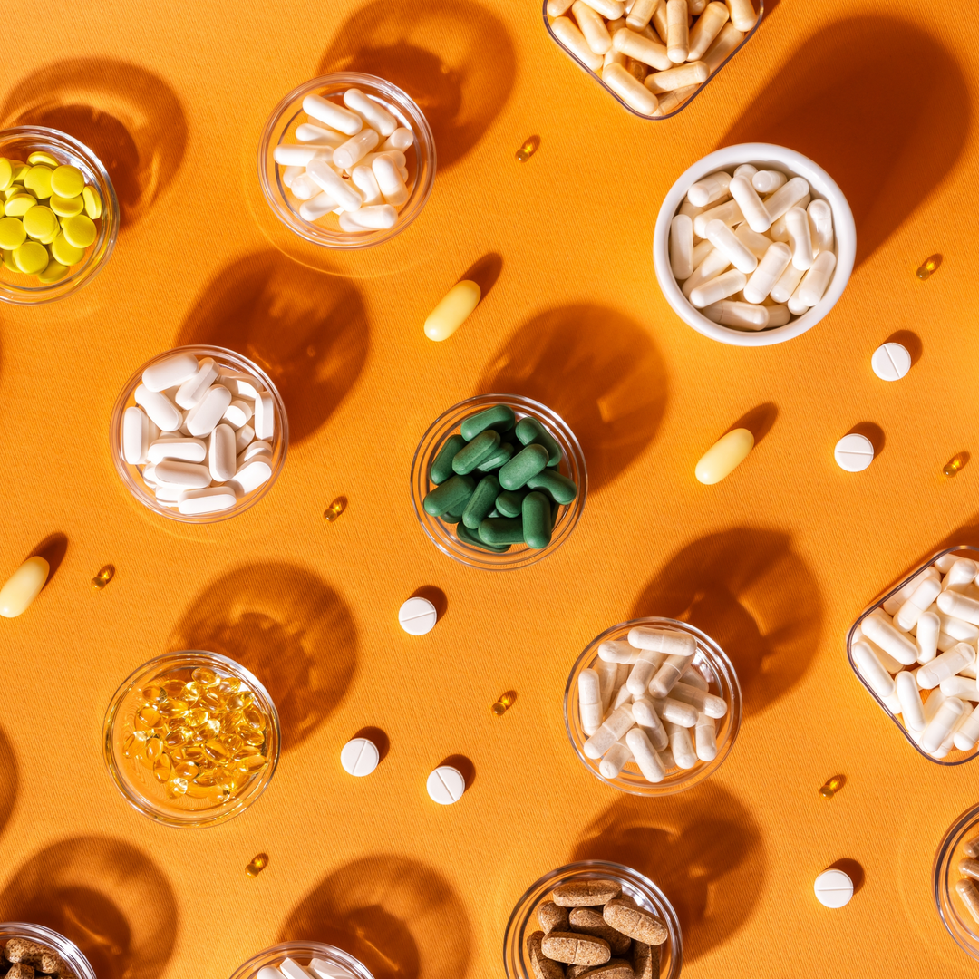 1.	Integratori multivitaminici e minerali su tavolo arancione – concetto di salute quotidiana